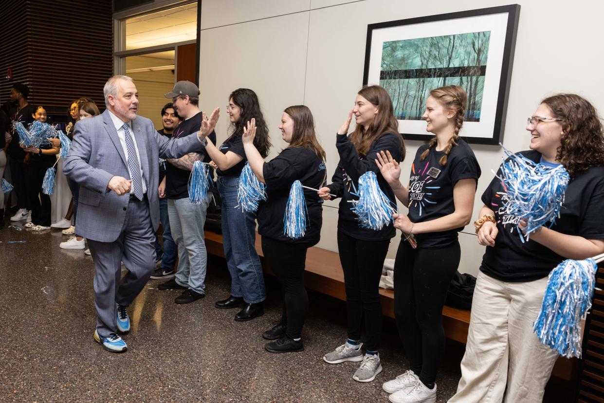 Joe Bertolino exchanges high-fives with students during inauguration ceremony at Stockton University on April 12, 2024.