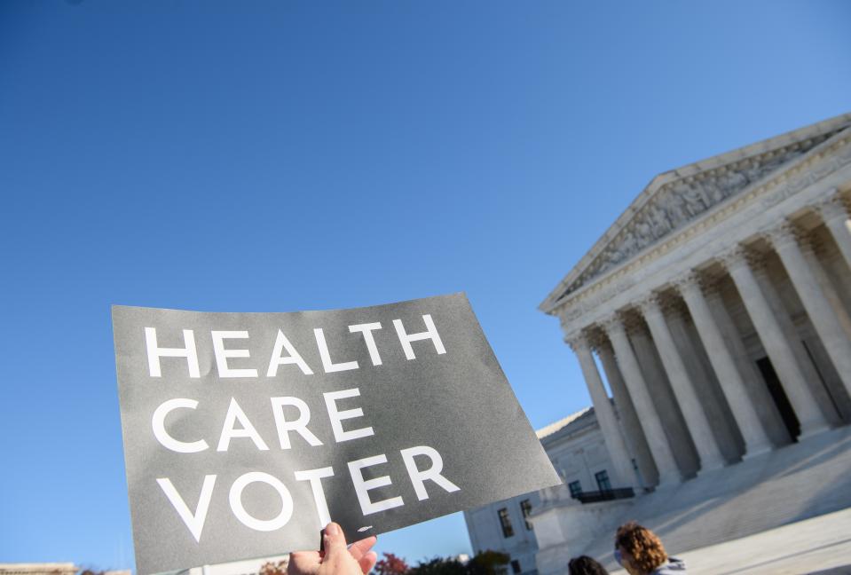 A demonstrator holds a sign in front of the US Supreme Court in Washington, DC, on November 10, 2020, as the high court opened arguments in the long-brewing case over the constitutionality of the 2010 Affordable Care Act, under which then-president Barack Obama's government sought to extend health insurance to people who could not afford it. - President Donald Trump's outgoing administration took aim in the US Supreme Court Tuesday at razing the "Obamacare" health program his predecessor built, a move which could cancel the health insurance of millions in the middle of the Covid-19 pandemic. (Photo by NICHOLAS KAMM / AFP) (Photo by NICHOLAS KAMM/AFP via Getty Images)