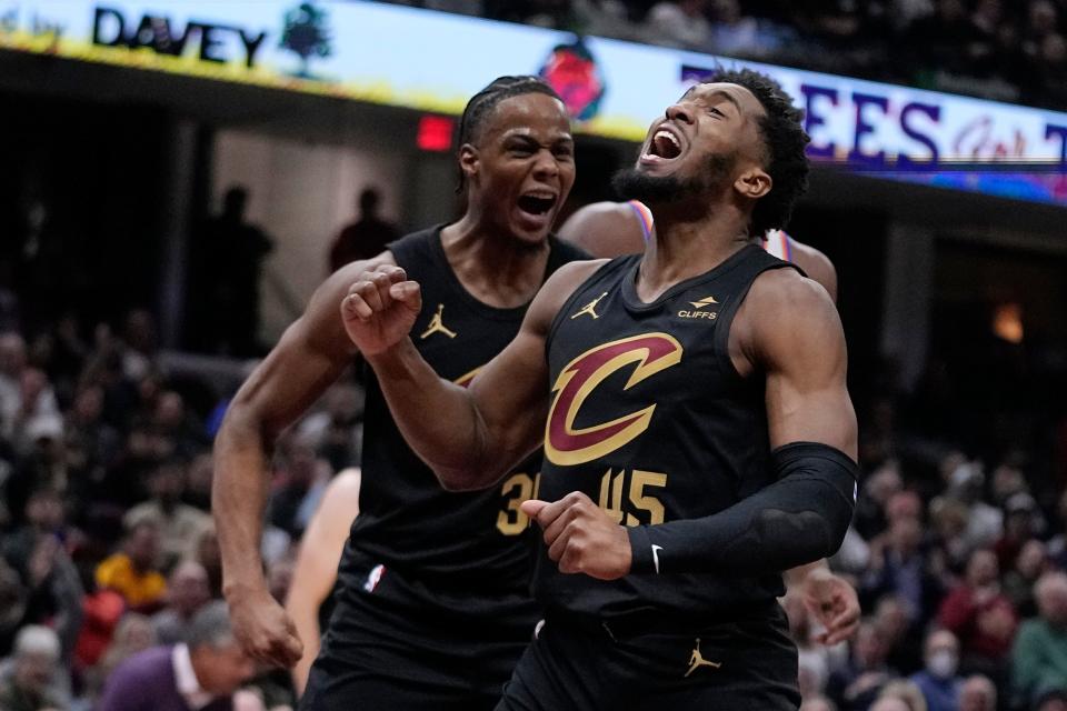 Cavaliers guard Donovan Mitchell (45) and forward Isaac Okoro, left, celebrate after Mitchell made a first-half basket while being fouled against the Knicks, Tuesday, Oct. 31, 2023, in Cleveland.