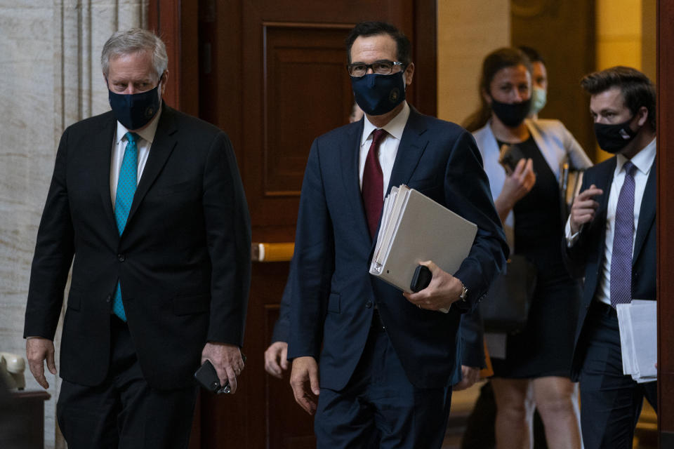 Treasury Secretary Steven Mnuchin, center, and White House chief of staff Mark Meadows, left, walk to House Speaker Nancy Pelosi's office on Capitol Hill in Washington, Wednesday, Aug. 5, 2020. Some clarity is beginning to emerge from the bipartisan Washington talks on a huge COVID-19 response bill. An exchange of offers and meeting devoted to the Postal Service on Wednesday indicates the White House is moving slightly in House Speaker Nancy Pelosi's direction on issues like aid to states and local governments and unemployment insurance benefits. But the negotiations have a long ways to go. (AP Photo/Carolyn Kaster)