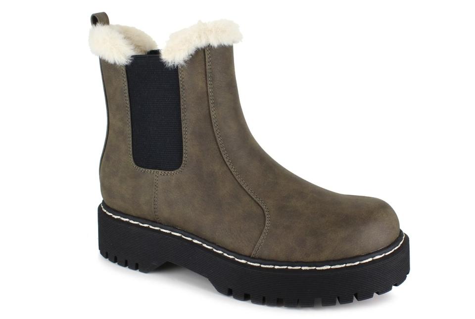 A brown Chelsea boot with white faux fur trim