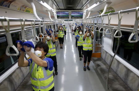 Workers wearing masks disinfect the interior of a subway train at a Seoul Metro's railway vehicle base in Goyang, South Korea, June 9, 2015. REUTERS/Kim Hong-Ji