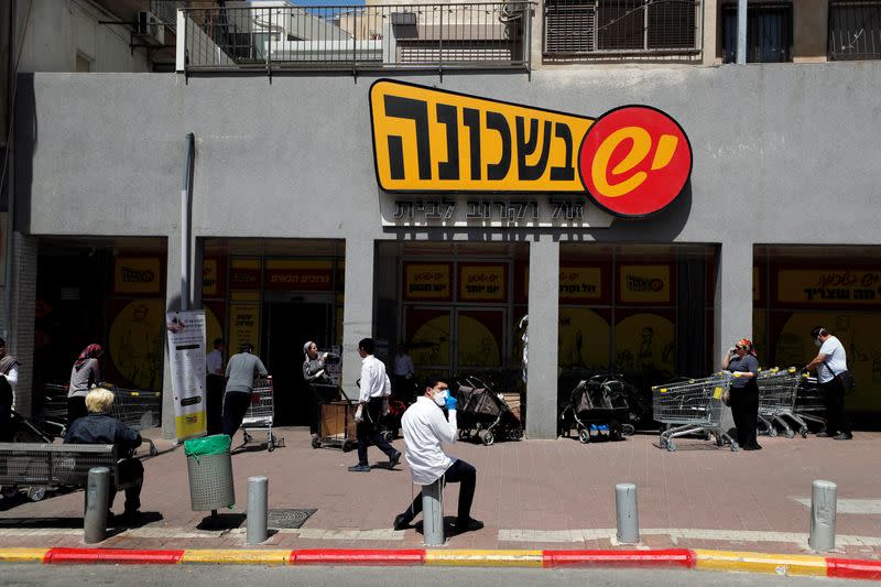 People stand outside a super market in Bnei Brak as Israel enforces a lockdown of the ultra-Orthodox Jewish town badly affected by coronavirus disease (COVID-19), Bnei Brak