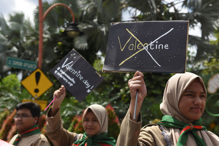 Muslim students hold posters during a protest against Valentine's Day celebrations in Surabaya, Indonesia, February 13, 2017 in this photo taken by Antara Foto. Antara Foto/Zabur Karuru/ via REUTERS