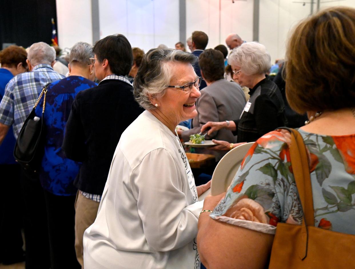 Pam Mann visits with Debbie Holman while waiting in the buffet line at the First Financial Bankshares stockholder meeting luncheon at the Abilene Convention Center Tuesday.