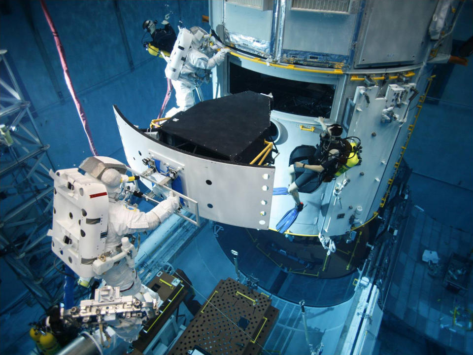 In this environment, astronauts can also practice repair maneuvers on satellites like this Hubble Space Telescope simulator.
