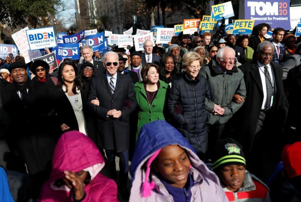 Democratic presidential candidates walk arm-in-arm with local African American leaders during the Martin Luther King Jr Day parade in Columbia, South Carolina, on 20 January.