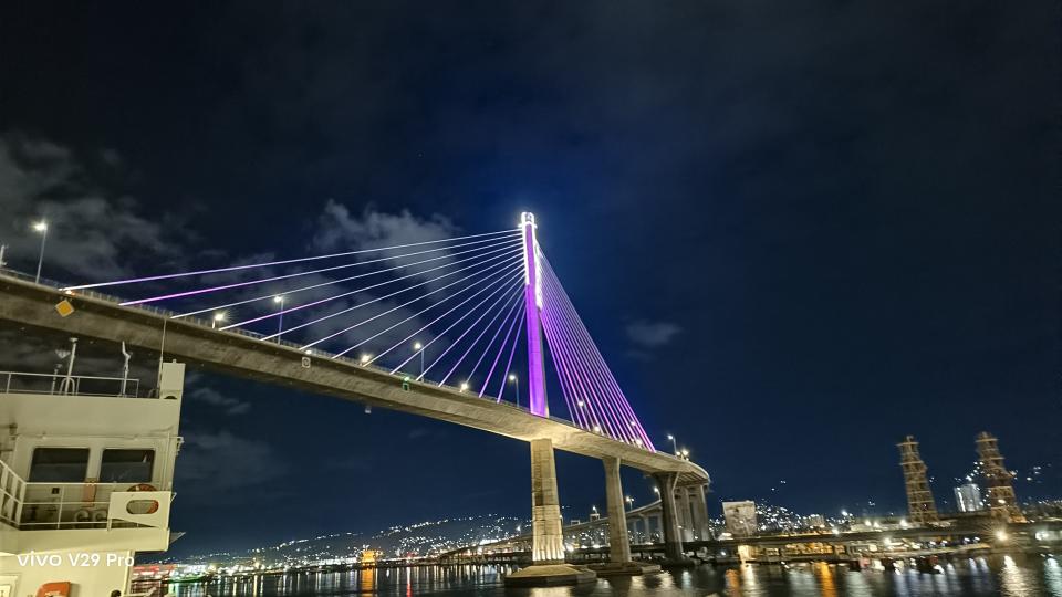 A night view of a bridge illuminated by a purple light, creating a captivating and enchanting atmosphere