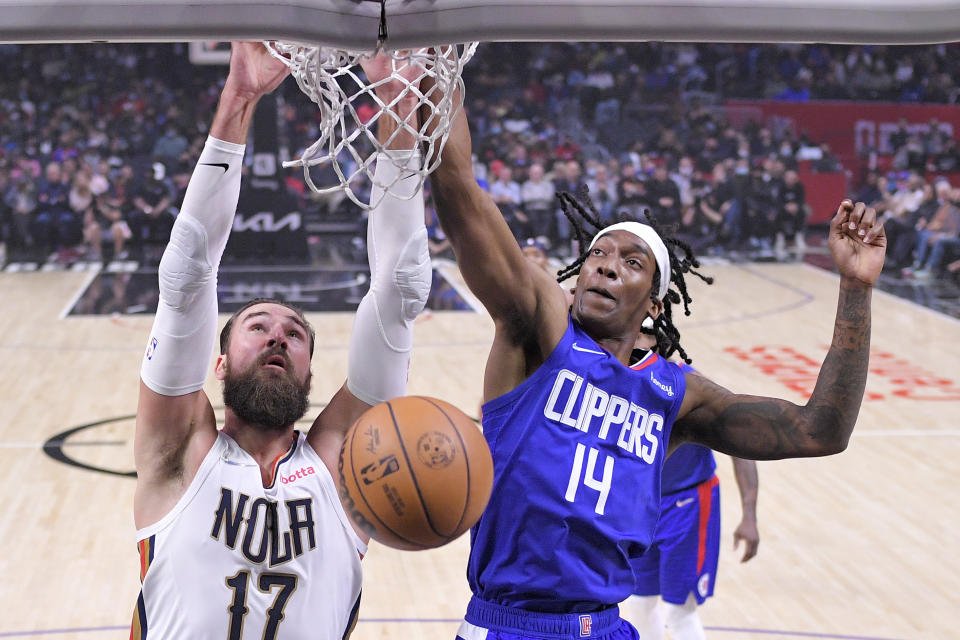 New Orleans Pelicans center Jonas Valanciunas, left, dunks as Los Angeles Clippers guard Terance Mann defends during the first half of an NBA basketball game Monday, Nov. 29, 2021, in Los Angeles. (AP Photo/Mark J. Terrill)