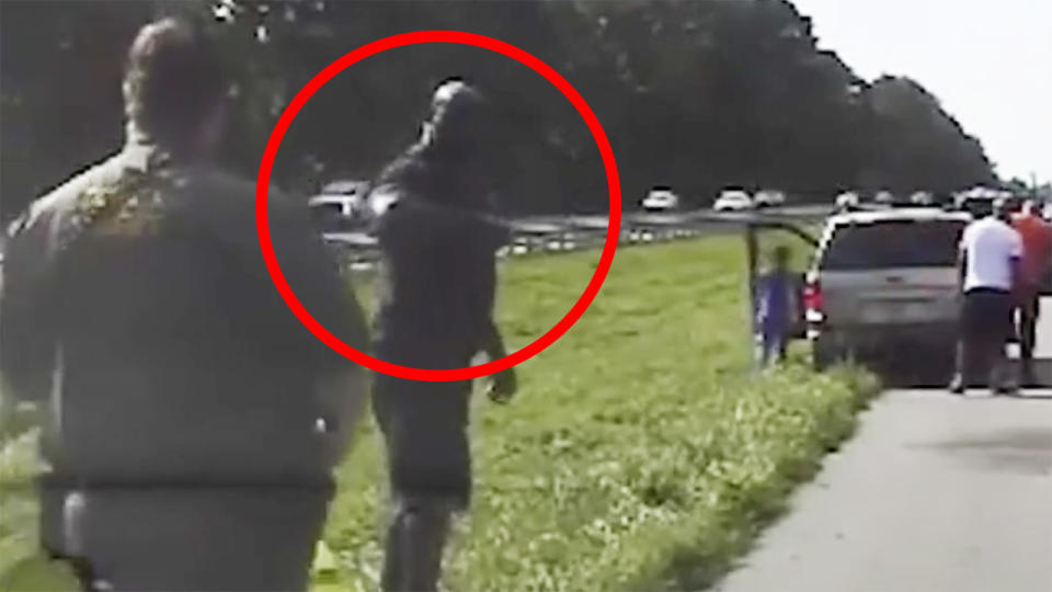 Shaquille O'Neal is pictured reaching out to fist-bump a Florida police officer after stopping to help a stranded driver.