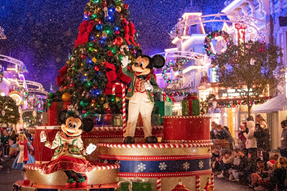 Mickey and Minnie wave to guests as snow appears to along Magic Kingdom's Main Street U.S.A.