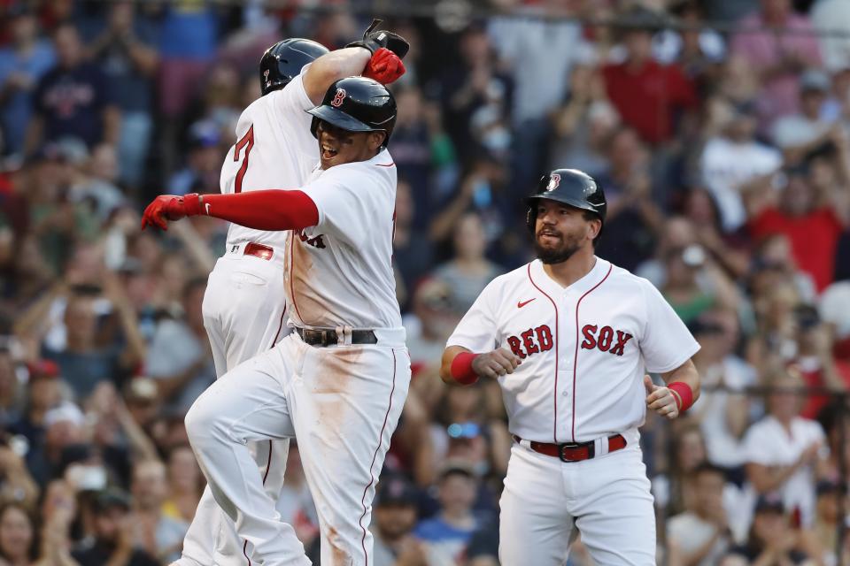 Boston Red Sox's Rafael Devers, center, celebrates his three-run home run that also drove in Christian Vazquez (7) and Kyle Schwarber, right, during the seventh inning of a baseball game against the Cleveland Indians, Saturday, Sept. 4, 2021, in Boston. (AP Photo/Michael Dwyer)