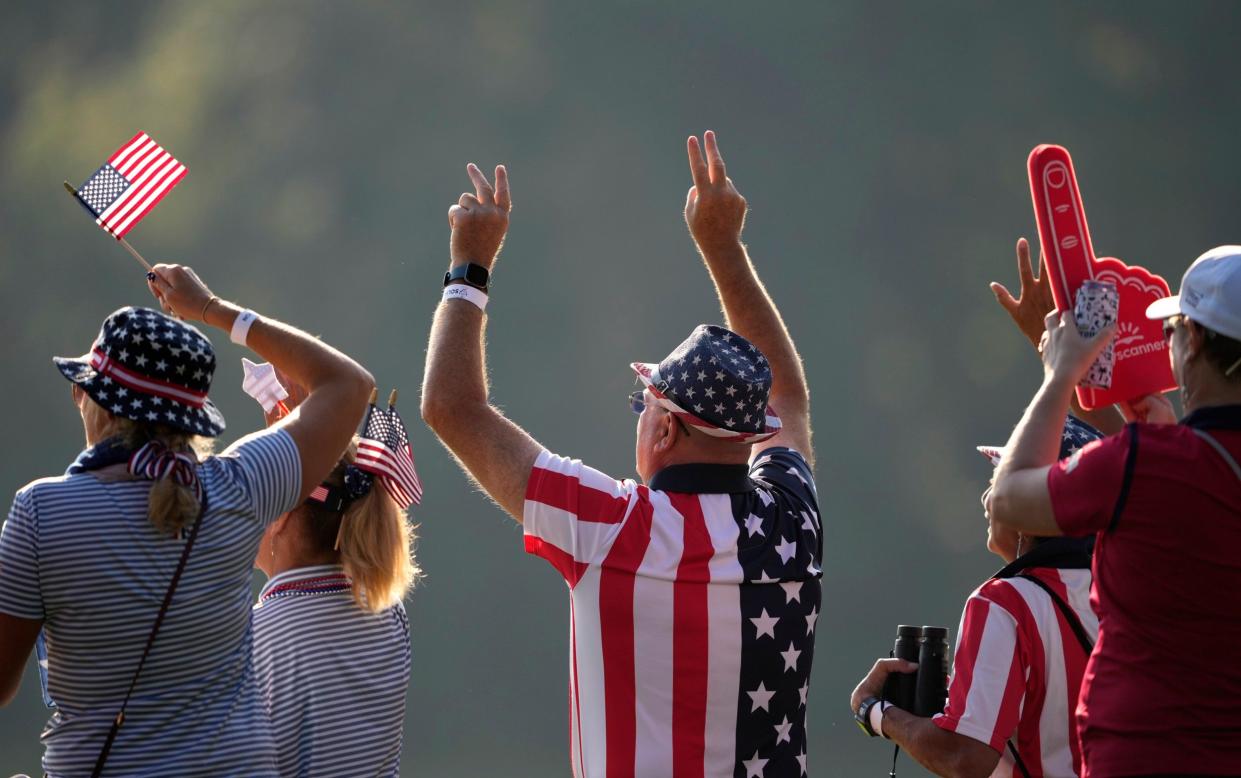 Fans wave to golfers during a Solheim Cup golf tournament foursome match