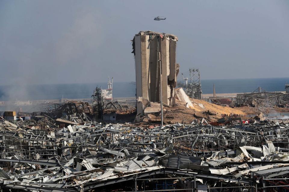 An army helicopter flies over the scene where an explosion hit the seaport of Beirut, Lebanon (AP)
