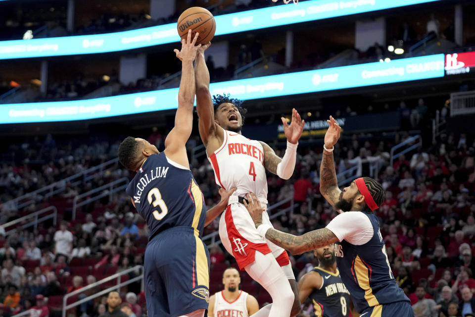 Houston Rockets guard Jalen Green (4) shoots as New Orleans Pelicans guard CJ McCollum (3) and forward New Orleans Pelicans forward Brandon Ingram, right, defend during the first half of an NBA basketball game Wednesday, Jan. 31, 2024, in Houston. (AP Photo/Eric Christian Smith)
