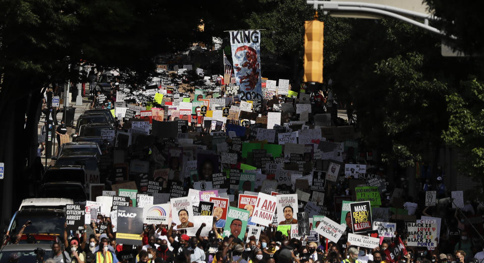 People march down the street towards the Georgia state capitol to protest against the mistreatment of black people and to press for policy change, Monday, June 15, 2020, in Atlanta. The NAACP March to the Capitol Monday coincided with the restart of the Georgia 2020 General Assembly. (AP Photo/Brynn Anderson)