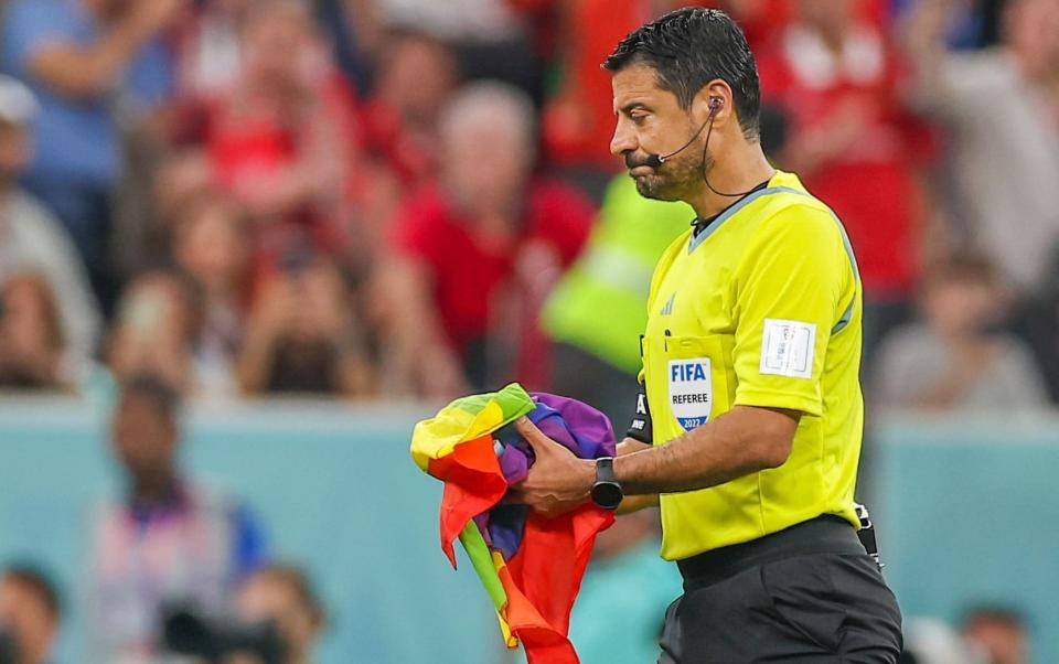 Referee Alireza Faghani removes a flag that brought onto the pitch by a pitch invader during the FIFA World Cup 2022 group H soccer match between Portugal and Uruguay at Lusail Stadium in Lusail, Qatar, 28 November 2022 - JOSE SENA GOULAO/EPA-EFE/Shutterstock