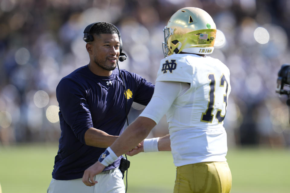 Notre Dame head coach Marcus Freeman congratulates quarterback Riley Leonard (13) after a touchdown during the first half of an NCAA college football game against Purdue in West Lafayette, Ind., Saturday, Sept. 14, 2024. (AP Photo/Michael Conroy)