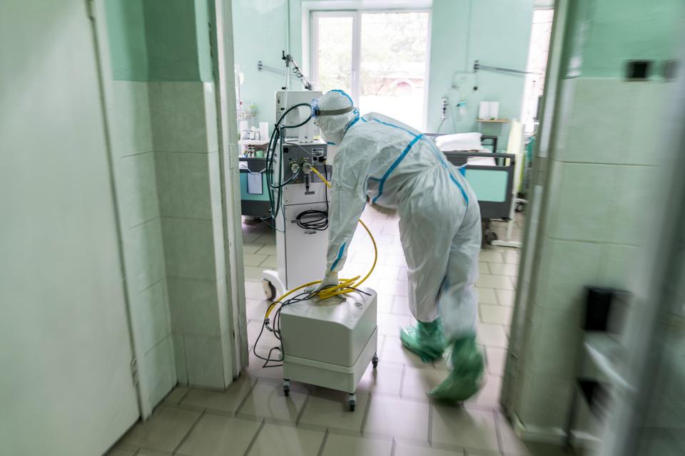 In this photo taken on Monday, May 4, 2020, a medic, wearing a special suit to protect against coronavirus, rolls medical equipment at an intensive care unit at a regional hospital in Chernivtsi, Ukraine. Ukraine's troubled health care system has been overwhelmed by COVID-19, even though it has reported a relatively low number of cases. (AP Photo/Evgeniy Maloletka)