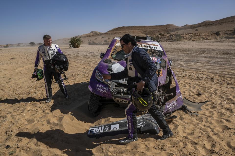 In this Tuesday, Jan. 14, 2020 photo, driver Peter Van Merksteijn, of Netherlands, foreground, and co-driver Michael Orr, of Great Britain, after crashing their Toyota during stage nine of the Dakar Rally between Wadi Al Dawasir and Haradth, Saudi Arabia. Formerly known as the Paris-Dakar Rally, the race was created by Thierry Sabine after he got lost in the Libyan desert in 1977. Until 2008, the rallies raced across Africa, but threats in Mauritania led organizers to cancel that year's event and move it to South America. It has now shifted to Saudi Arabia. The race started on Jan. 5 with 560 drivers and co-drivers, some on motorbikes, others in cars or in trucks. Only 41 are taking part in the Original category. (AP Photo/Bernat Armangue)