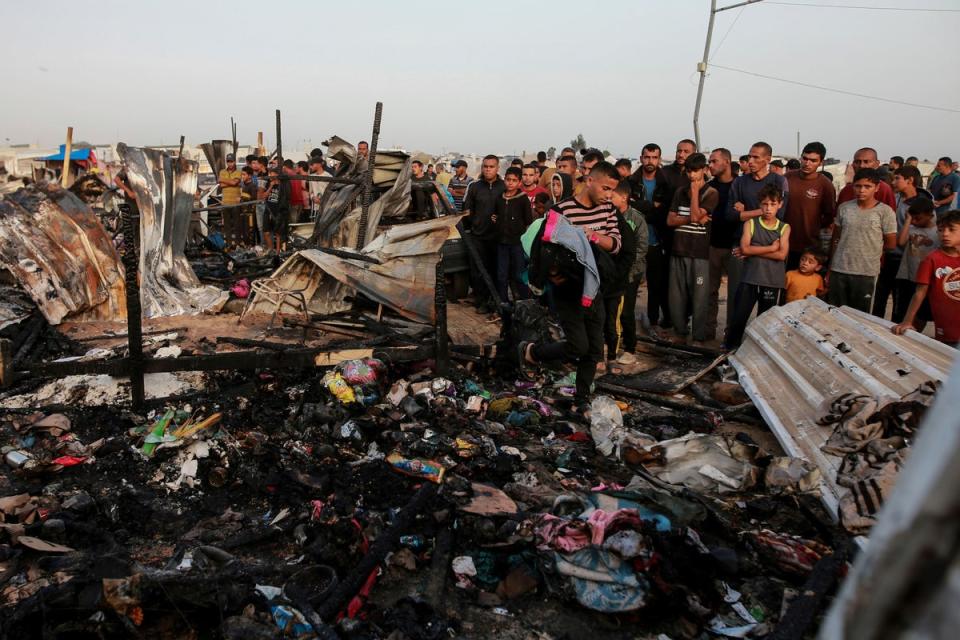 Palestinians look at the destruction after an Israeli strike where displaced people were staying in Rafah (Jehad Alshrafi/AP/PA) (AP)