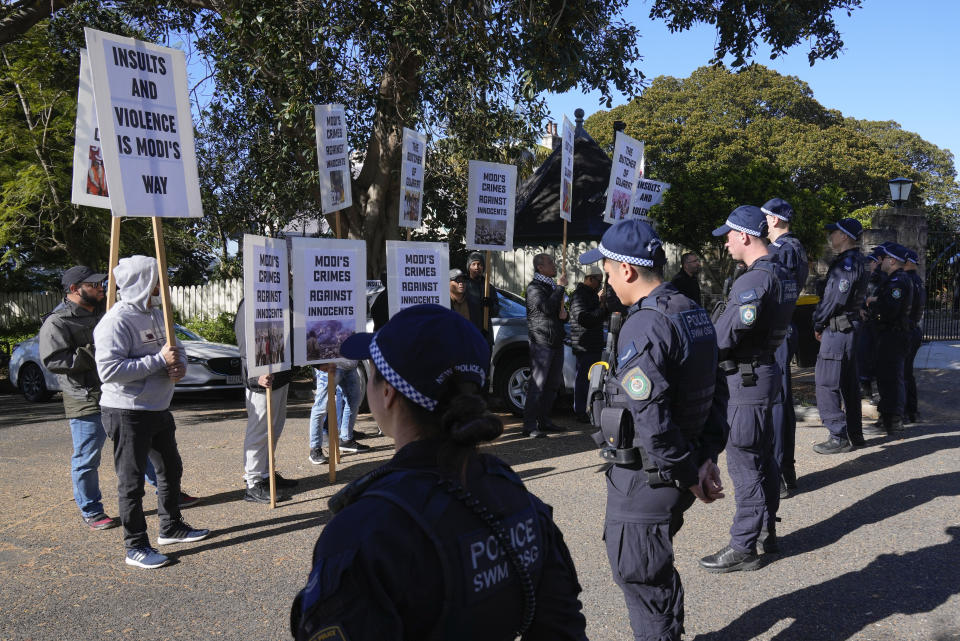 Police stand near protesters outside Kirribilli House where Indian Prime Minister Narendra Modi and Australian Prime Minister Anthony Albanese will hold talks in Sydney, Australia, Wednesday, May 24, 2023. (AP Photo/Rick Rycroft)