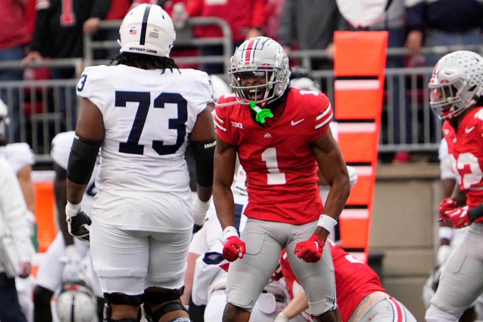 Oct 21, 2023; Columbus, Ohio, USA; Ohio State Buckeyes cornerback Davison Igbinosun (1) celebrates in front of Penn State Nittany Lions offensive lineman Caedan Wallace (73) during the NCAA football game at Ohio Stadium.