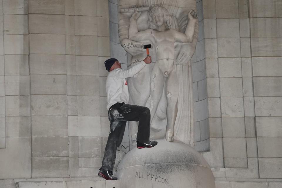 A man after he climbed onto a statue outside the BBC’s headquarters in central London (Ian West/PA) (PA Wire)