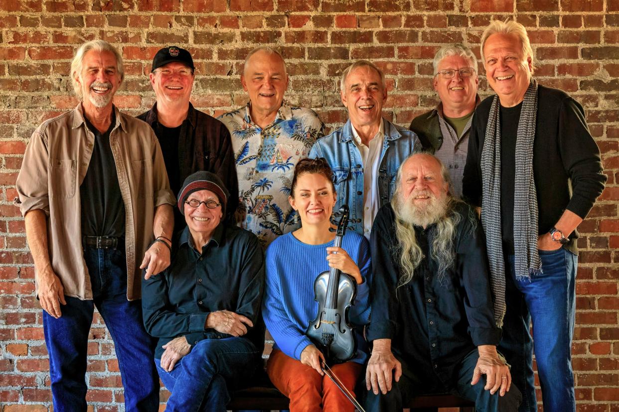 Back row left to right: Ron Gremp, Dave Painter, Bill Jones, Nick Sibley, Kelly Brown and John Dillion; front row left to right: Ruell Chappell, Molly Healey and Michael Supe Granda pose for a portrait. The nine musicians make up the Ozark Mountain Daredevils, an American country rock band established in 1972.