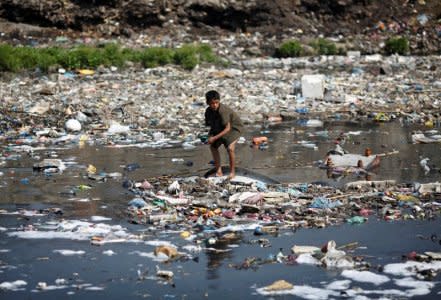 FILE PHOTO: A boy looks for plastic bottles at the polluted Bagmati River in Kathmandu March 22, 2013. REUTERS/Navesh Chitrakar/File Photo