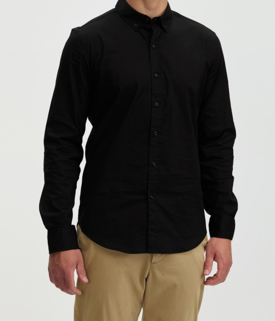 Double Oak Mills Stretch LS Shirt from The Iconic. A black button-down long-sleeved shirt worn over beige chinos.