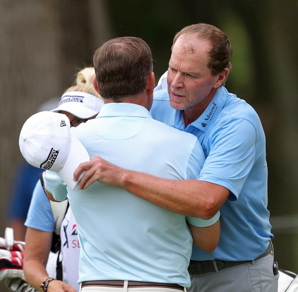 Steve Stricker hugs Justin Leonard after finishing the second round of the Bridgestone Senior Players Tournament at Firestone Country Club on Friday.