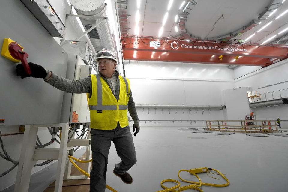 Jim O'Neill, of Salem, N.H., a senior safety manager, pulls a lever as he prepares to operate a crane Wednesday, Oct. 11, 2023, at Commonwealth Fusion Systems, in Devens, Mass. Commonwealth is trying to create fusion inside what's called a tokamak. Nuclear fusion, which would be a new source of carbon-free energy, melds two hydrogen atoms together to produce a helium atom and a lot of energy. (AP Photo/Steven Senne)