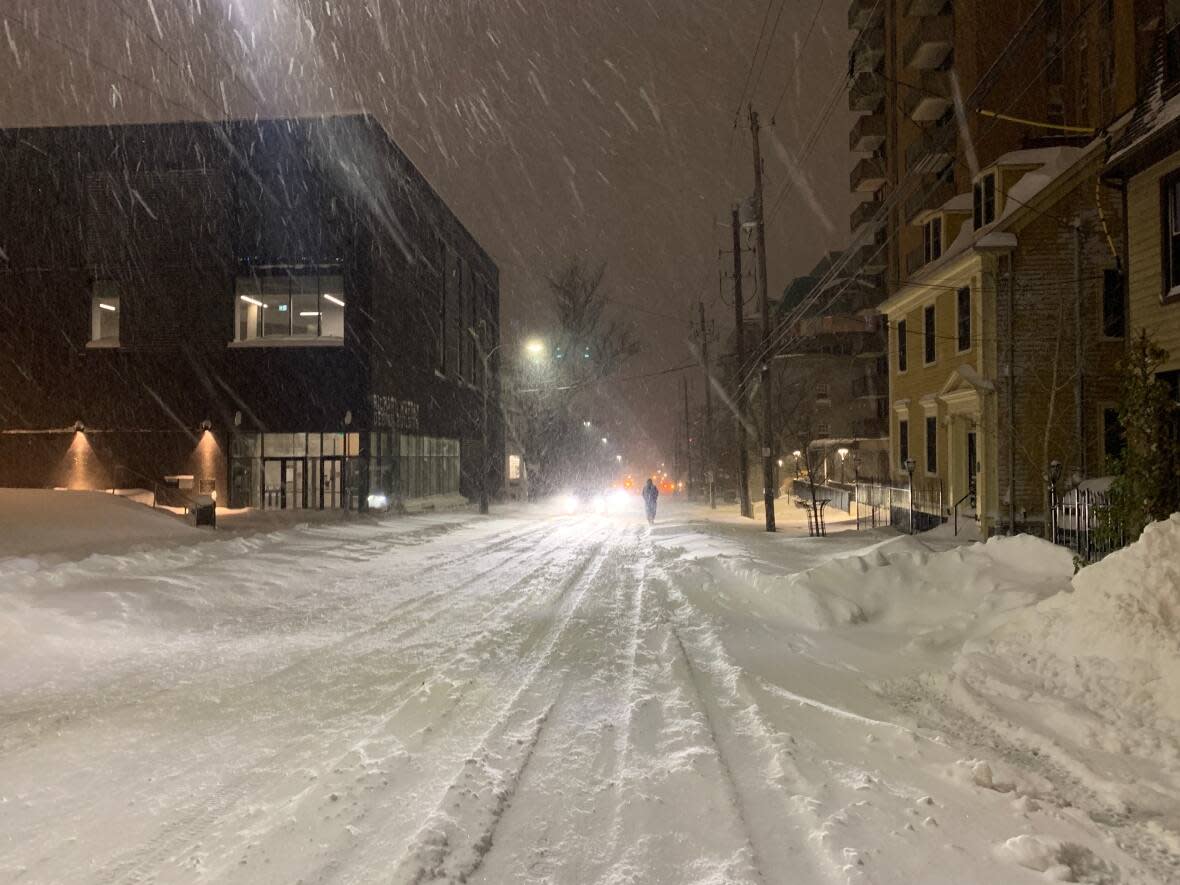 A person walks in the middle of a snow-covered street in downtown Halifax early Thursday morning. (Nicola Seguin/CBC - image credit)