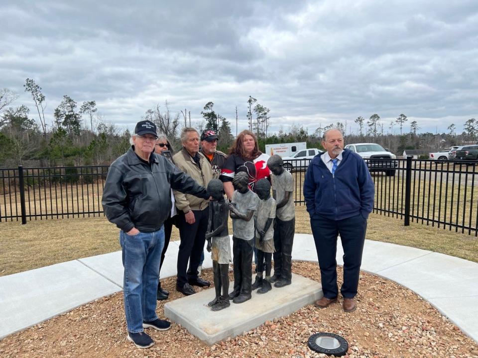 Orlando sculptor Frank Castelluccio, to the right, poses with Gene Luker and other White House Boys and family members at the  memorial dedication for the victims of the former Arthur G. Dozier School for Boys in Jackson County