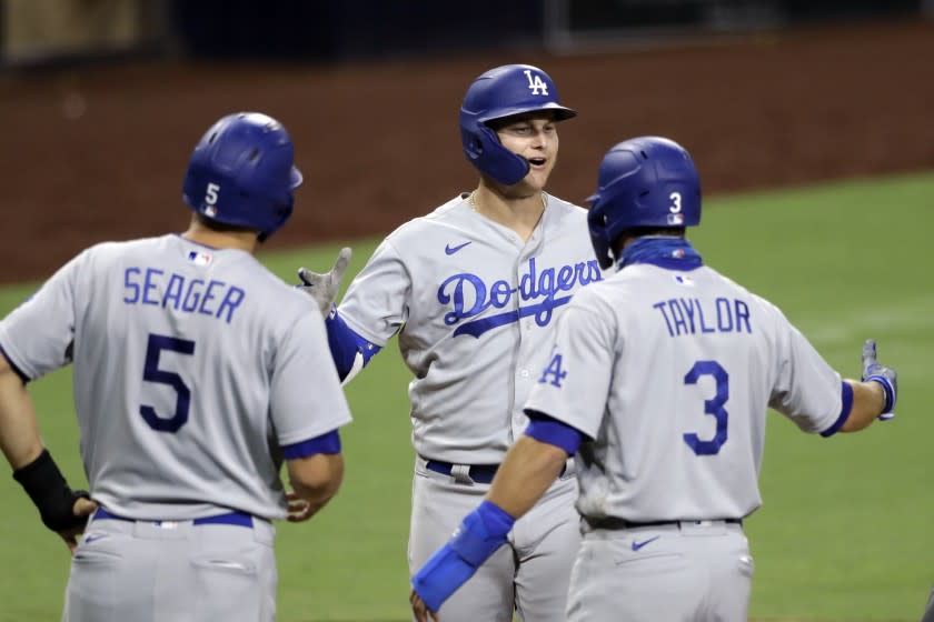 Los Angeles Dodgers' Joc Pederson, center, is greeted by Chris Taylor (3) and Corey Seager (5) after hitting a three-run home run during the sixth inning of a baseball game against the San Diego Padres, Wednesday, Aug. 5, 2020, in San Diego. (AP Photo/Gregory Bull)