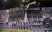 Assam police personnel arrange arms and ammunition handed over by cadres of different rebel groups during a surrender ceremony in Gauhati, India, Thursday, Jan. 23, 2020. More than 600 insurgents belonging to eight different rebel groups have surrendered to Indian authorities in this troubled northeastern state, responding to the government’s peace initiative to rejoin mainstream society. (AP Photo/Anupam Nath)