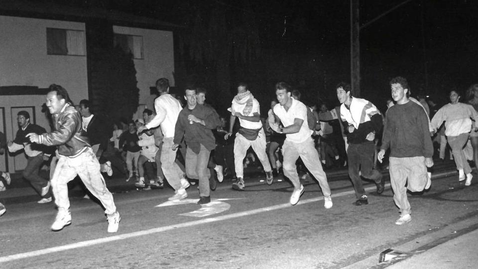 As things heat up around midnight Saturday, the crowd makes a hasty retreat from a police line advancing on the corner of California and Foothill boulevards.