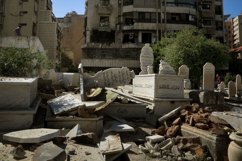 Tombstones are seen destroyed in a local cemetery, after it was affected by an Israeli air strike targeting a nearby apartment building in central Beirut. Marwan Naamani/dpa