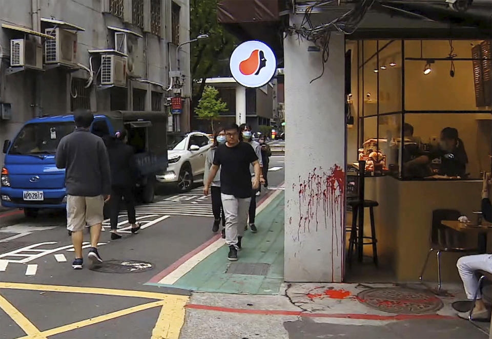 In this image made from video, a coffee shop with red paint on the wall in Taipei Tuesday, April 21, 2020. The founder of Hong Kong’s Causeway Bay Book shop, Lam Wing-kee was attacked by unidentified man who threw red paint at him on Tuesday morning in Taipei. According to police, an unknown man in mask and dark clothes suddenly came to throw red paint at Lam while he was alone at a coffee shop. (EBC via AP)