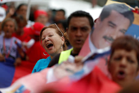 Supporters of Venezuela's President Nicolas Maduro hold placards with his image and shout slogans as they attend a campaign rally in Caracas, Venezuela May 16, 2018. Picture taken May 16, 2018. REUTERS/Carlos Garcia Rawlins
