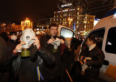 Protesters wear gas masks during a meeting to support EU integration at European square in Kiev, November 25, 2013. REUTERS/Vasily Fedosenko