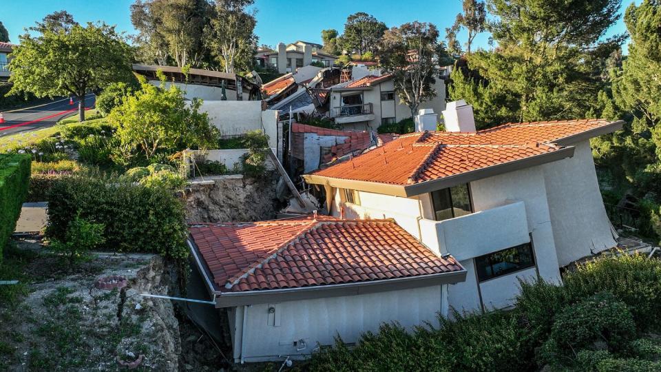 Lopsided, damaged homes on a hillside.