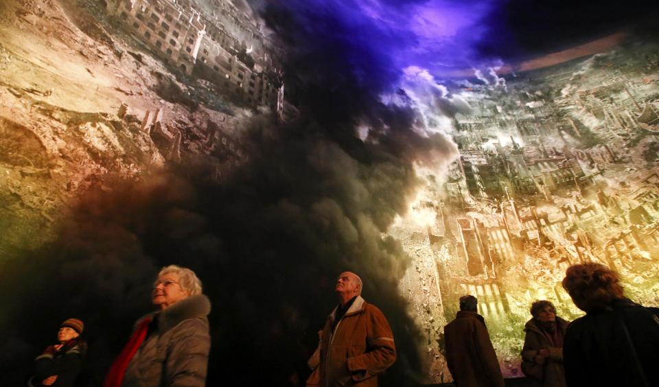 People watch the 'Dresden 1945' 360 degrees panorama showing the destroyed city of Dresden after the bombing raids during the World War Two in February 1945 at the Panometer in Dresden