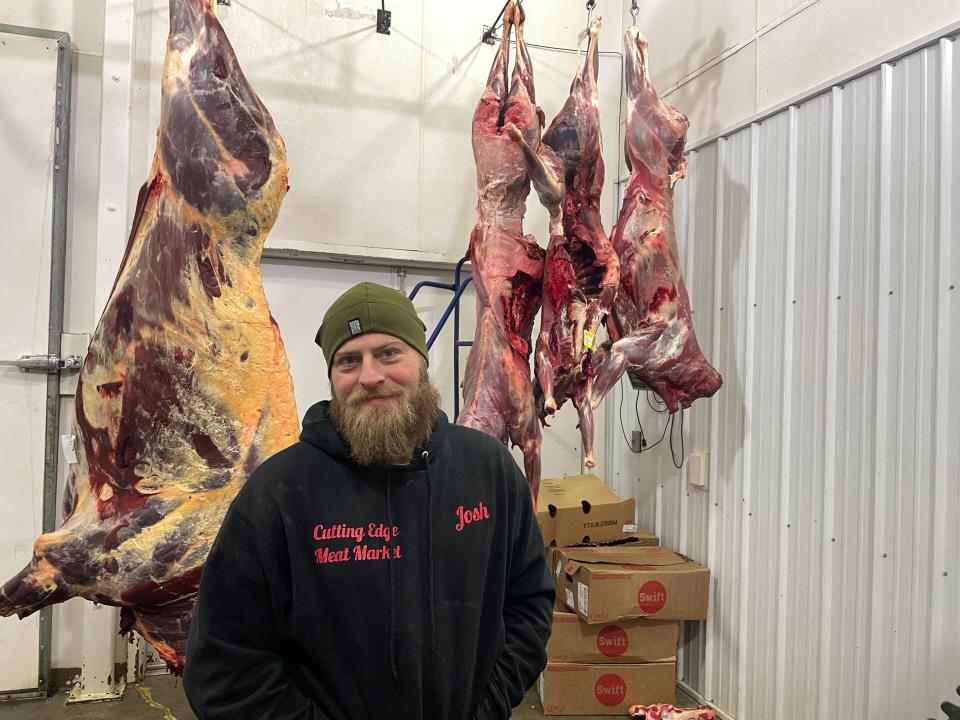 Josh Clark is a manager at Cutting Edge Meat Market in Piedmont, S.D., one of the only remaining Black Hills butcher shops that processes wild game for hunters. Clark stood between a skinned buffalo and skinned deer in a storage room at the store.