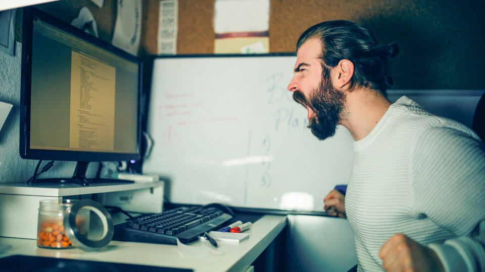 Close-up of an angry man working at the home office.