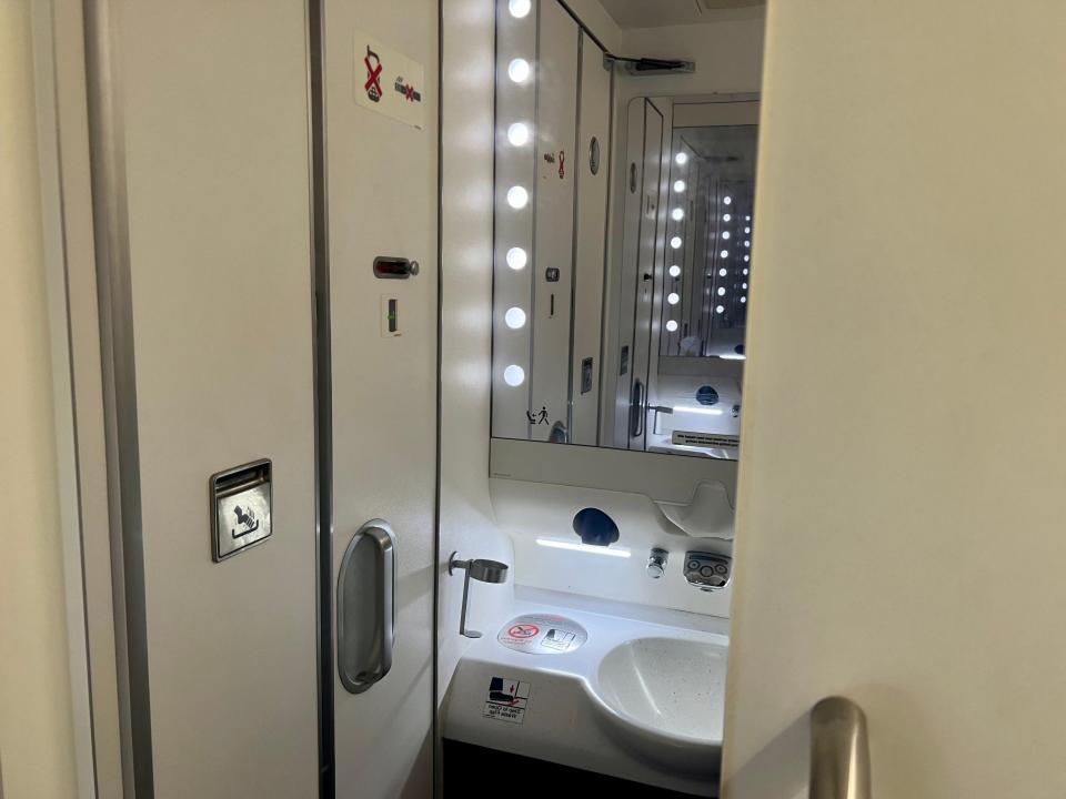 The full body mirror in the bathroom with the sink on the reflection.