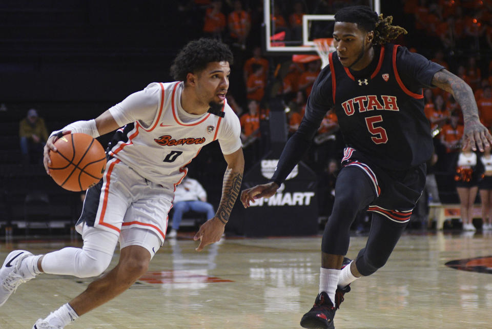 Oregon State guard Jordan Pope (0) drives against Utah guard Deivon Smith (5) during the second half of an NCAA college basketball game Thursday, March 7, 2024, in Corvallis, Ore. Oregon State won 92-85. (AP Photo/Mark Ylen)