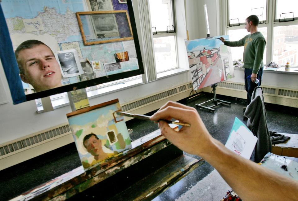 Using a mirror, Joshua Nierodzinski works on a self-portrait as fellow Art 5 classmate Neil Gauthier works on his own painting at the UMass Dartmouth Star Store campus fourth floor student studios.