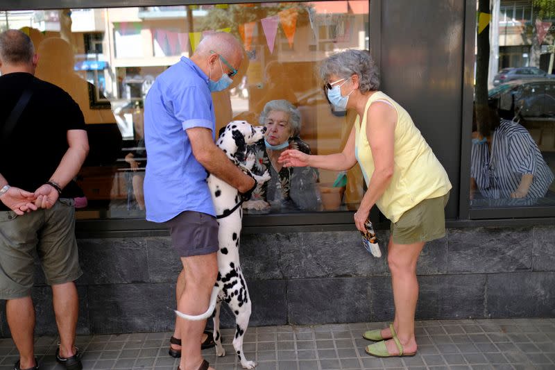 Elderly people get love through nursing home glass front as COVID-19 surges